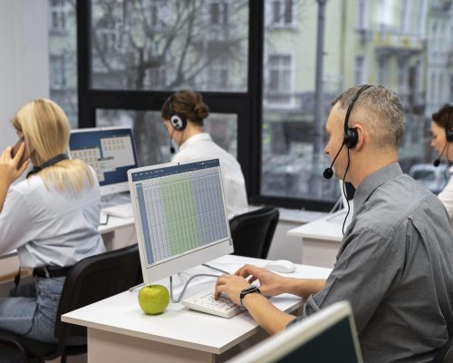 colleagues-working-together-call-center-with-headphones-min